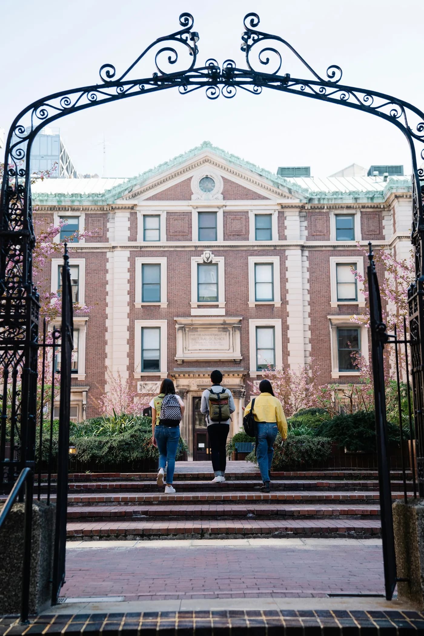 Students walking through an archway toward a historic university building